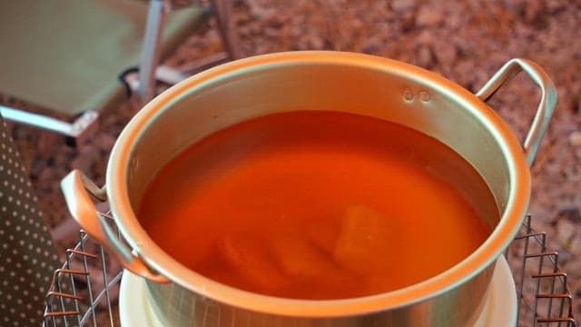 Adding fish cake skewers and vegetables to the boiling nickel-silver pot