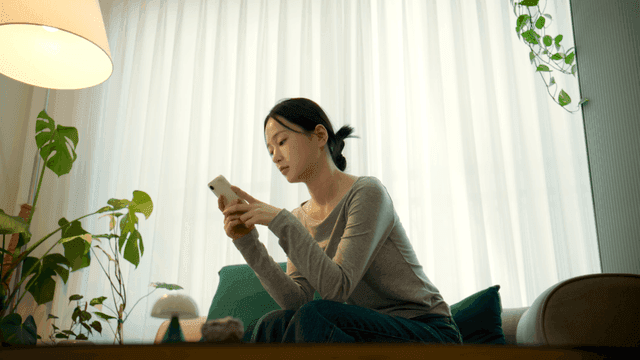 Woman using her smartphone in living room