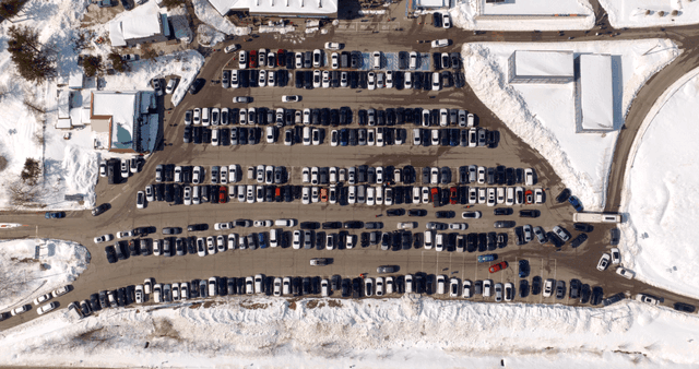 Snow-covered parking lot with many cars