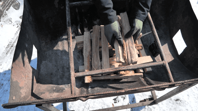 Sight of stacking firewood in metal stove