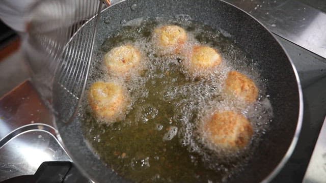 Frying croquettes in hot oil in frying pan