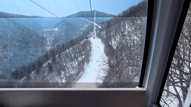 Cable car view of snowy mountain slopes