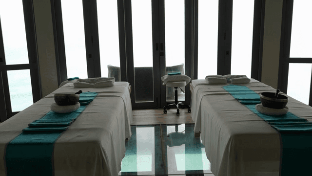 유리 바닥과 마사지 침대가 있는 스파 룸