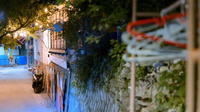 Quiet alley with a parked scooter at night