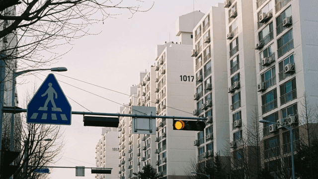 Apartment complex visible behind blinking traffic light