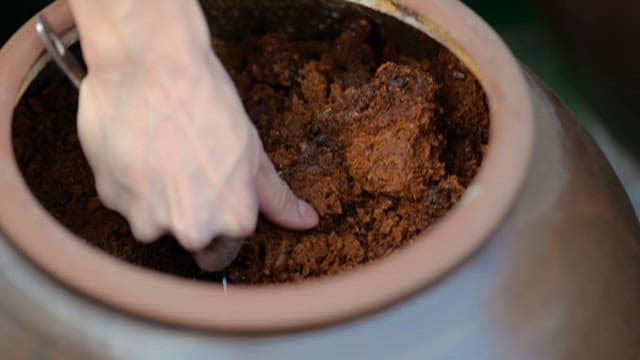 Scooping Fermented Soybean Paste from a Earthenware and Putting it into a Bowl