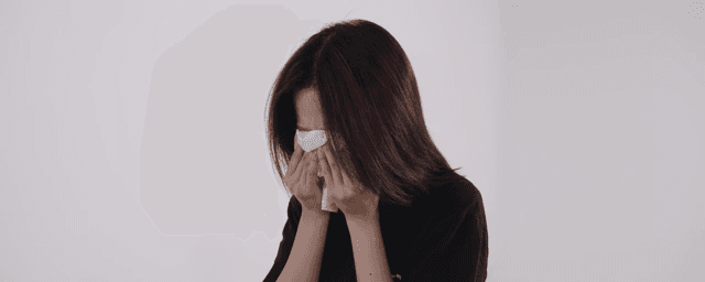 실내에서 휴지로 눈물을 닦는 여성