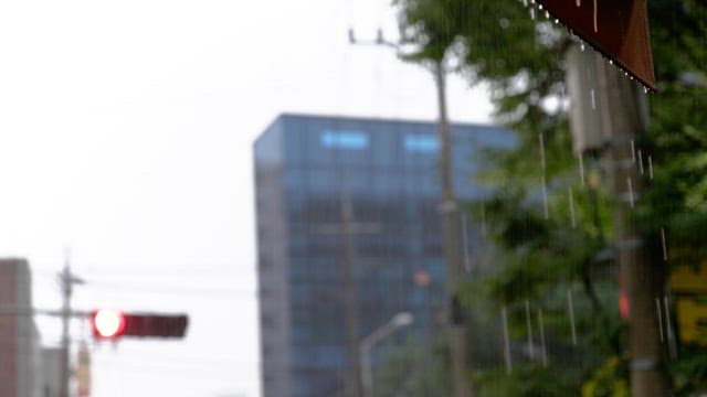 Traffic lights and buildings seen blurry on a rainy day