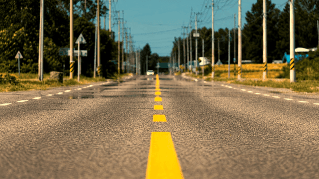 Long road stretching into distance, shimmering with heat haze
