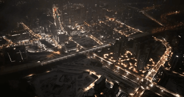 구름을 통과하며 보이는 밤에 불빛이 비치는 번화한 도시