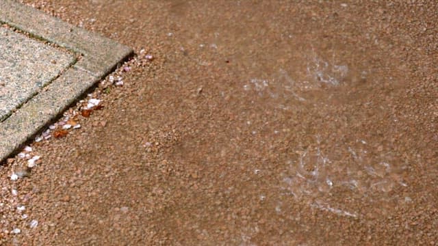 Puddles on wet ground on a cement floor on a rainy day