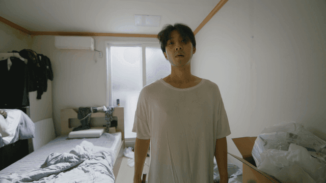 Man holding a hammer in a messy room