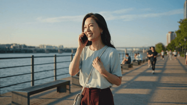 Woman talking on the phone by the riverside