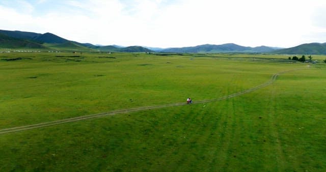 넓은 초원을 달리는 오토바이