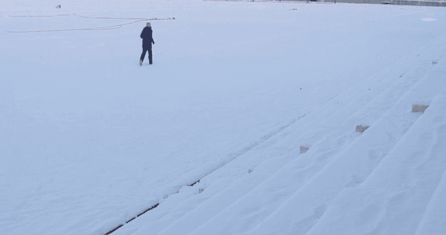 Person running on a snow-covered playground