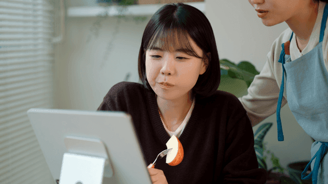 Two women enjoying a snack indoors