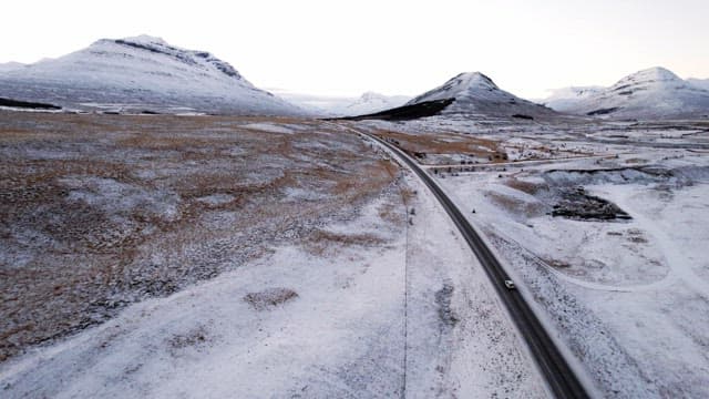 눈 덮인 산과 차가 있는 도로