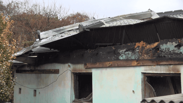 Old house with damaged roof in rainy rural area