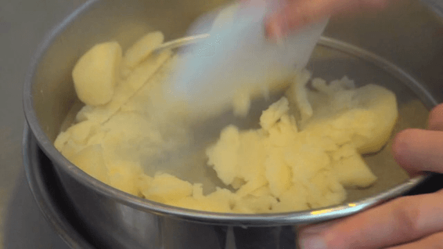 주방에서 감자를 으깨는 장면