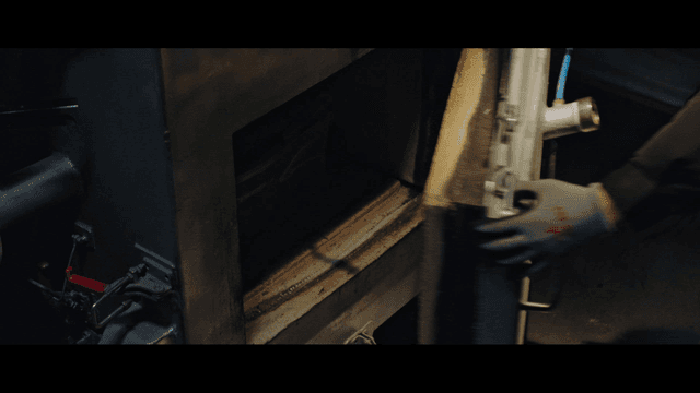 작업자가 대형 산업용 용광로를 여는 모습