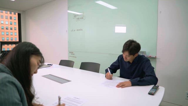 사무실에서 서류에 서명하는 두 동료