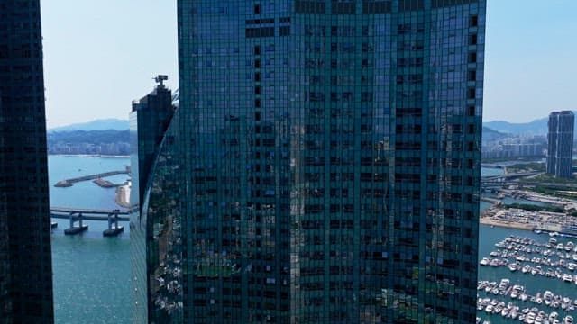 High-rise building with a unique and modern appearance and sea under a sunny sky