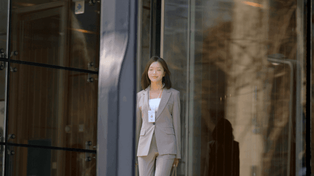A woman in a suit exiting a building