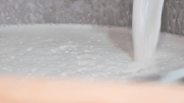 Soy milk pouring into large container