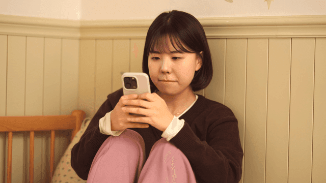 Young woman using smartphone in room