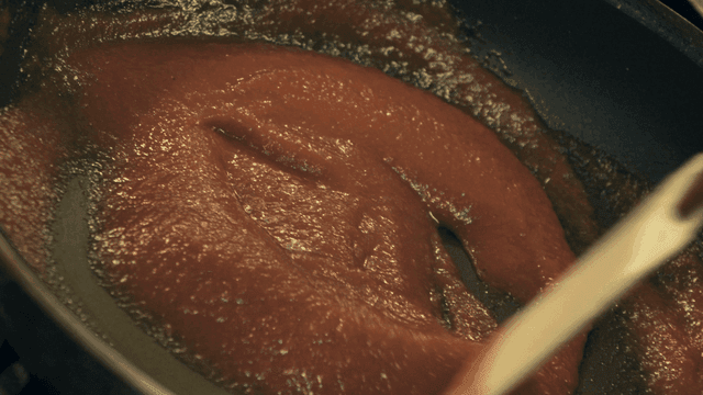 Tomato sauce being stirred in a pan