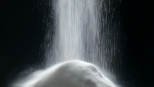 어두운 배경에서 떨어지는 하얀 유산균 가루