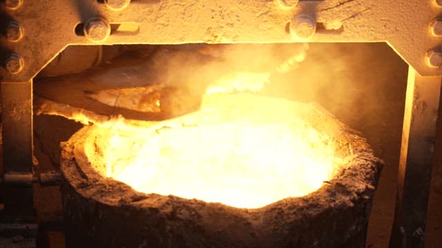 Worker closing the lid of a furnace with molten metal