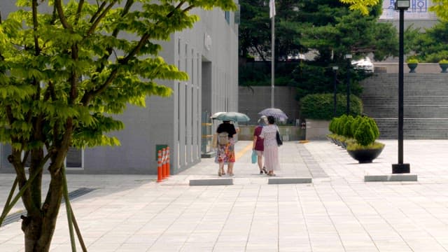 People walking with umbrellas on a sunny day