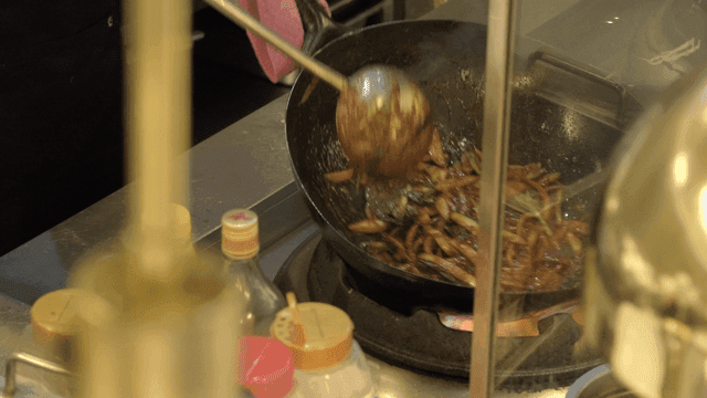 Chef cooking stir-fried vegetables in a wok
