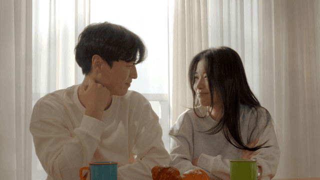 Happy couple enjoying breakfast at set morning table