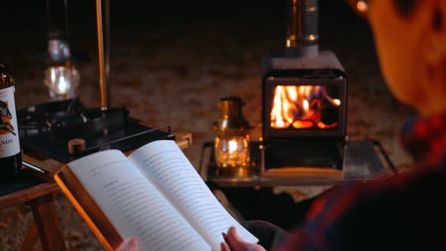 Reading by the Cozy Fire of a Camping Stove