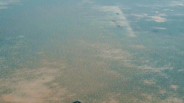 잔잔한 표면의 염전과 소금 수확 장비