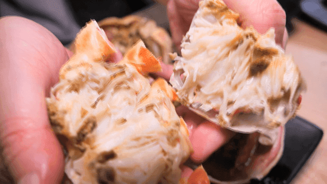 익힌 대게찜 껍질을 가르는 손