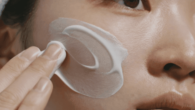 Woman applying cream to her face