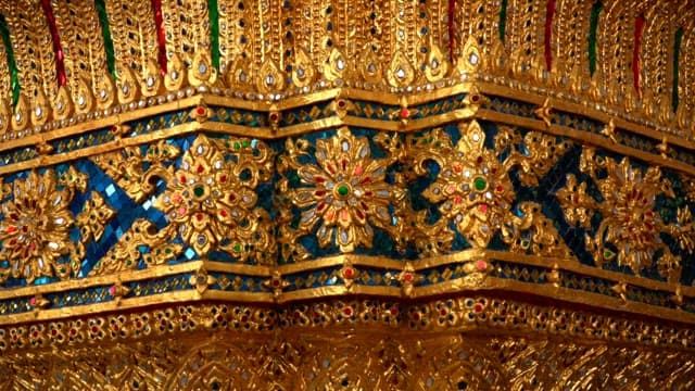 Walls of the Thai temple ornately decorated with gold and jewels