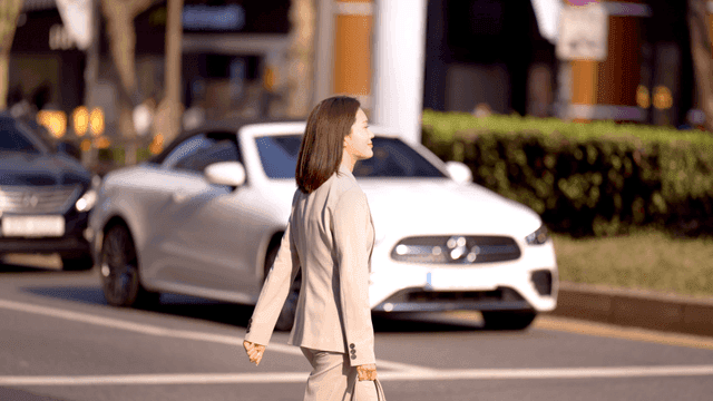 Woman in suit crossing crosswalk