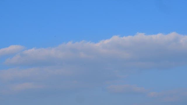 Peaceful mid-afternoon sky with clouds floating calmly