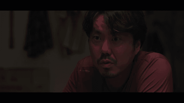 Man drinking alcohol in dark kitchen