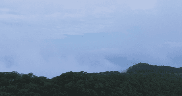 Lush green mountains under a cloudy sky