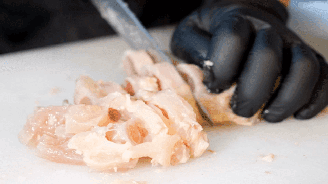 Beef tendon being cut on cutting board