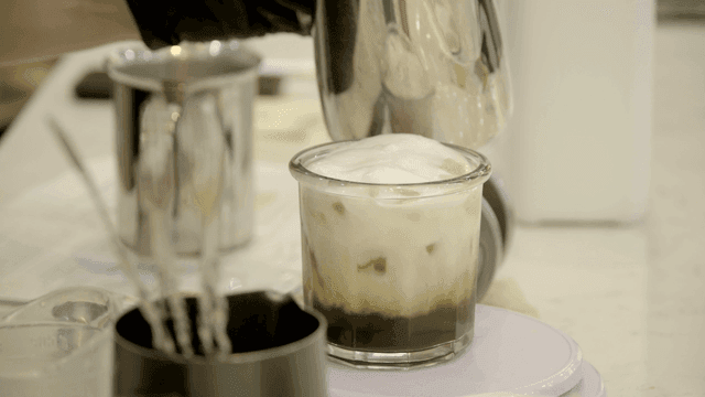 Cream poured into latte coffee