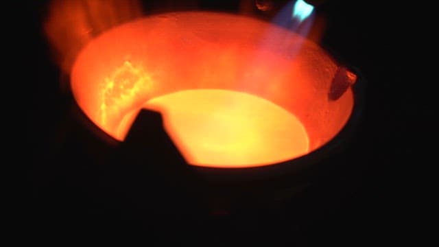 Molten metal being heated with a torch