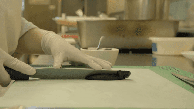 Chef applying black sauce in kitchen