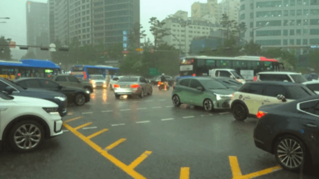 비 오는 날 바쁜 도시 교차로의 교통