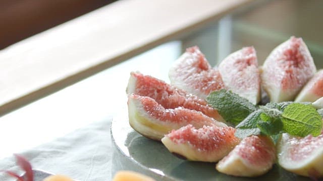 접시 위에 가지런히 썰린 무화과와 감 조각